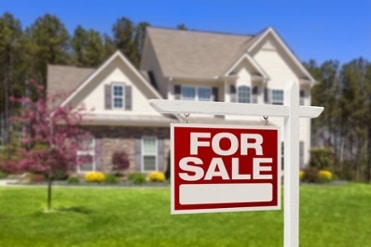 Home with a red for sale sign in the front yard