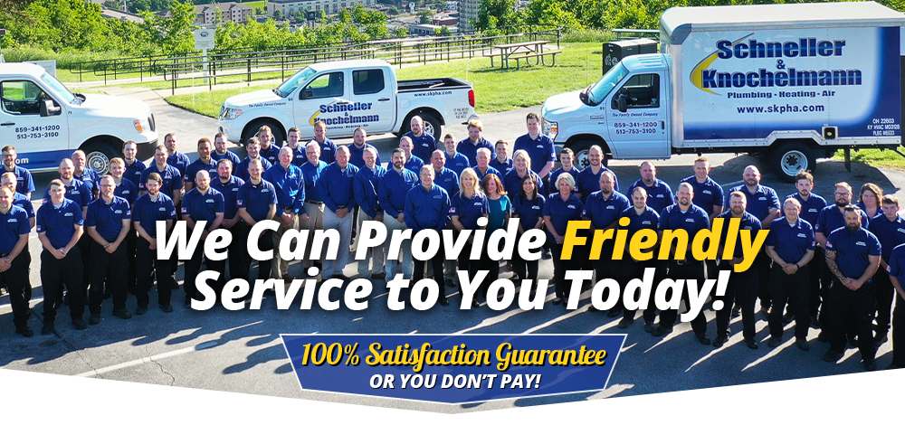 Schneller Knochelmann team standing in front of their trucks. Overlaying text "We Can Provide Friendly Service to You Today! 100% Satisfaction Guarantee or You Don't Pay!"