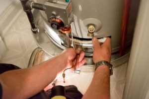 Plumber installing water heater in tight space